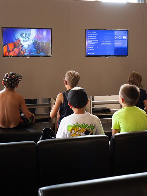 Sala giochi con supereroi, TV e arredi colorati per bambini.