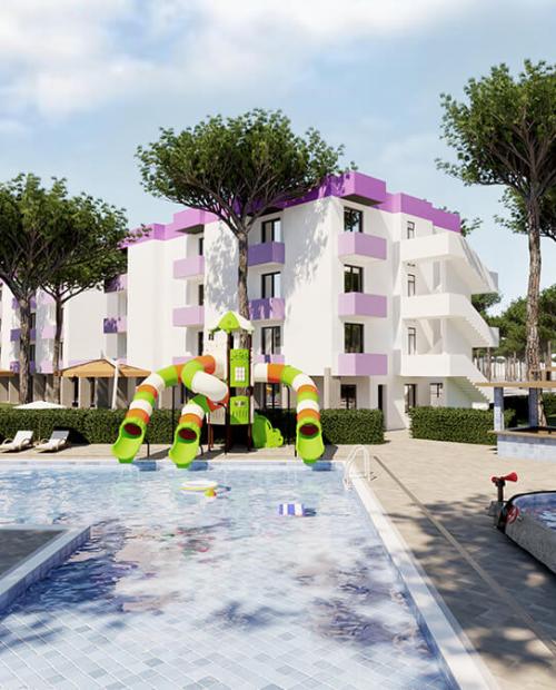 Piscina con giochi colorati, edifici moderni e alberi rigogliosi, atmosfera di vacanza.